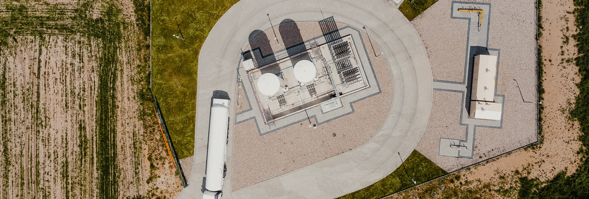 Stacja regazyfikacji LNG widziana z góry (z drona), zbiorniki LNG, parownice, ciężarówka cysterna