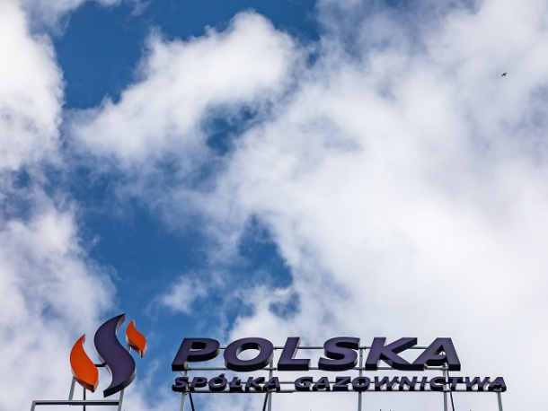Logotyp Polskiej Spółki Gazownictwa na szczycie budynku, niebo z chmurami w tle