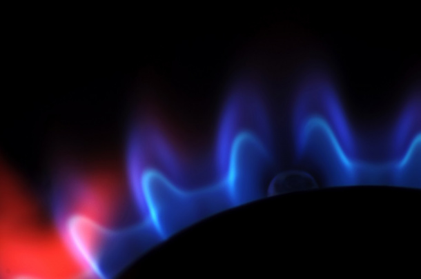 Niebieski płomień gazowego palnika na czarnym tle