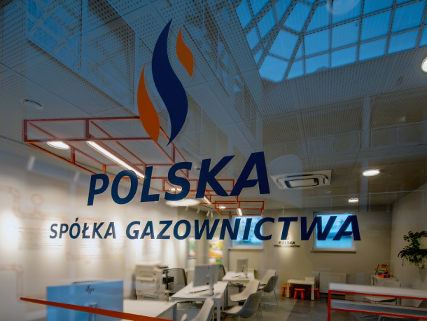 Logotyp Polskiej Spółki Gazownictwa na przeszkolonych drzwiach prowadzących do biura obsługi klienta