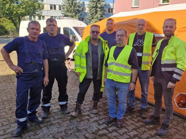 Grupa pracowników Polskiej Spółki Gazownictwa w ubraniach roboczych na terenach popowodziowych