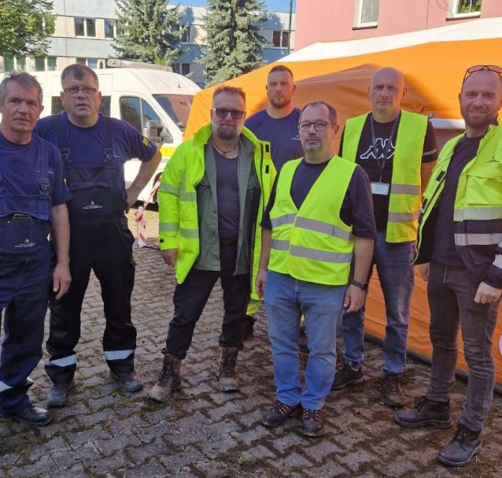 Grupa pracowników Polskiej Spółki Gazownictwa w ubraniach roboczych na terenach popowodziowych
