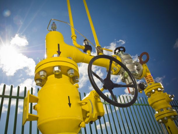 PSG gas infrastructure – yellow pipes with black coating, blue sky and sun in the background