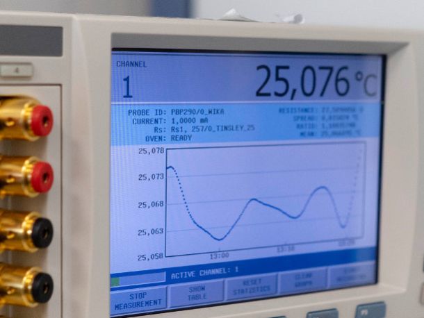 Urządzenie badawcze z widocznym ekranem, na którym widać wykres temperatury, oraz czterema interfejsami wejściowymi po lewej stronie