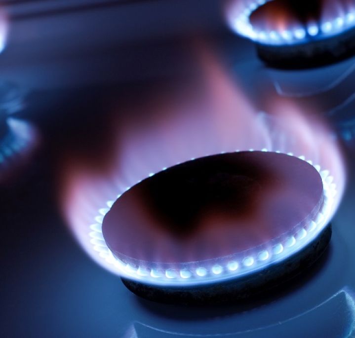 Three lit gas burners, light blue flame