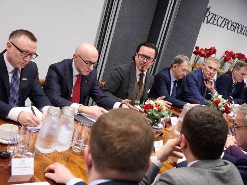Uczestnicy debaty Rzeczpospolitej siedzą przy stole i rozmawiają